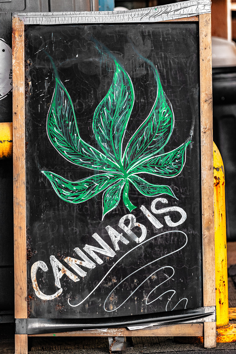 Sandwich board with a chalk drawing of a cannabis leaf