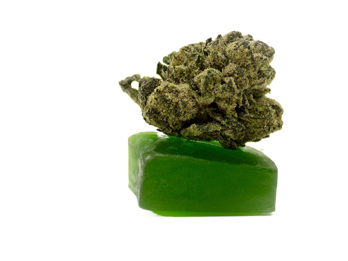 Green cannabis gummy with a flower bud on top