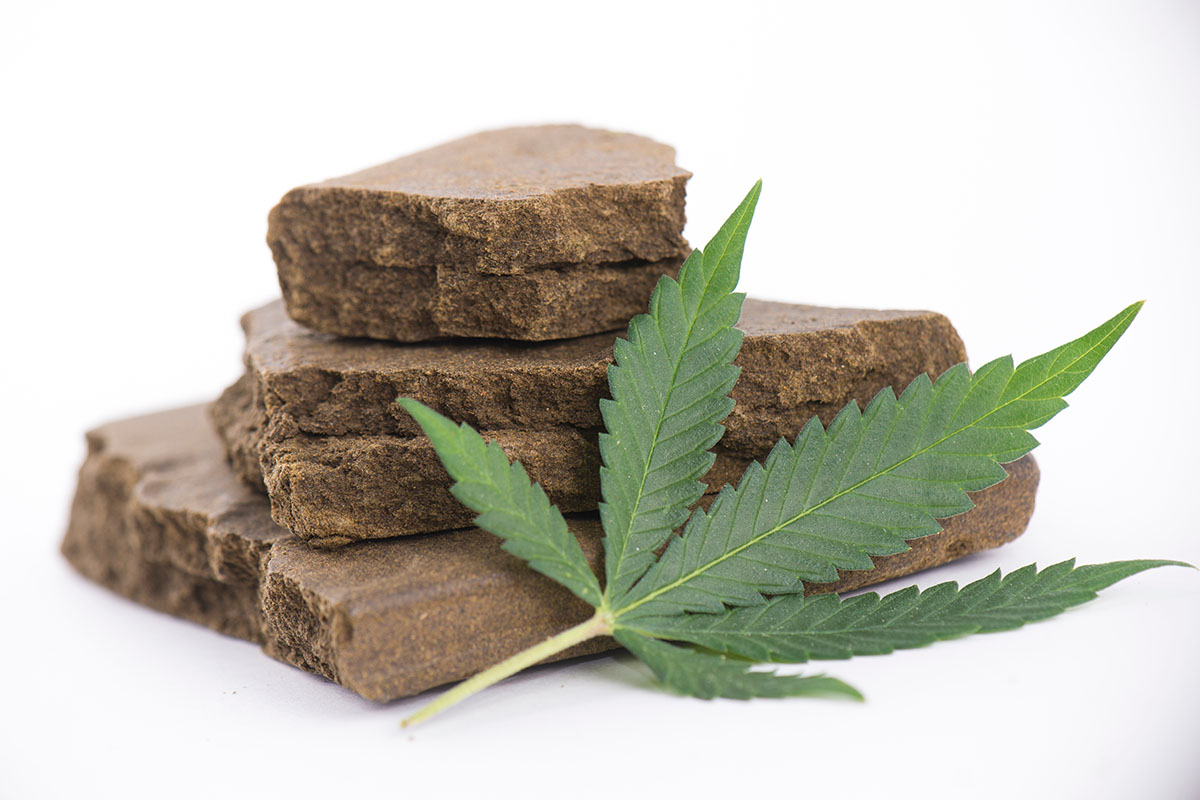 A stack of hash cakes with a cannabis leaf in front