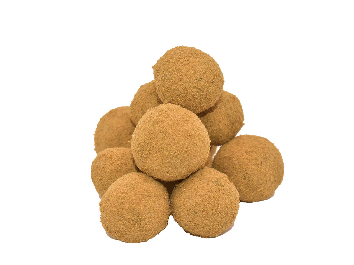 A pile of kief-coated moon rocks sits against a white background.