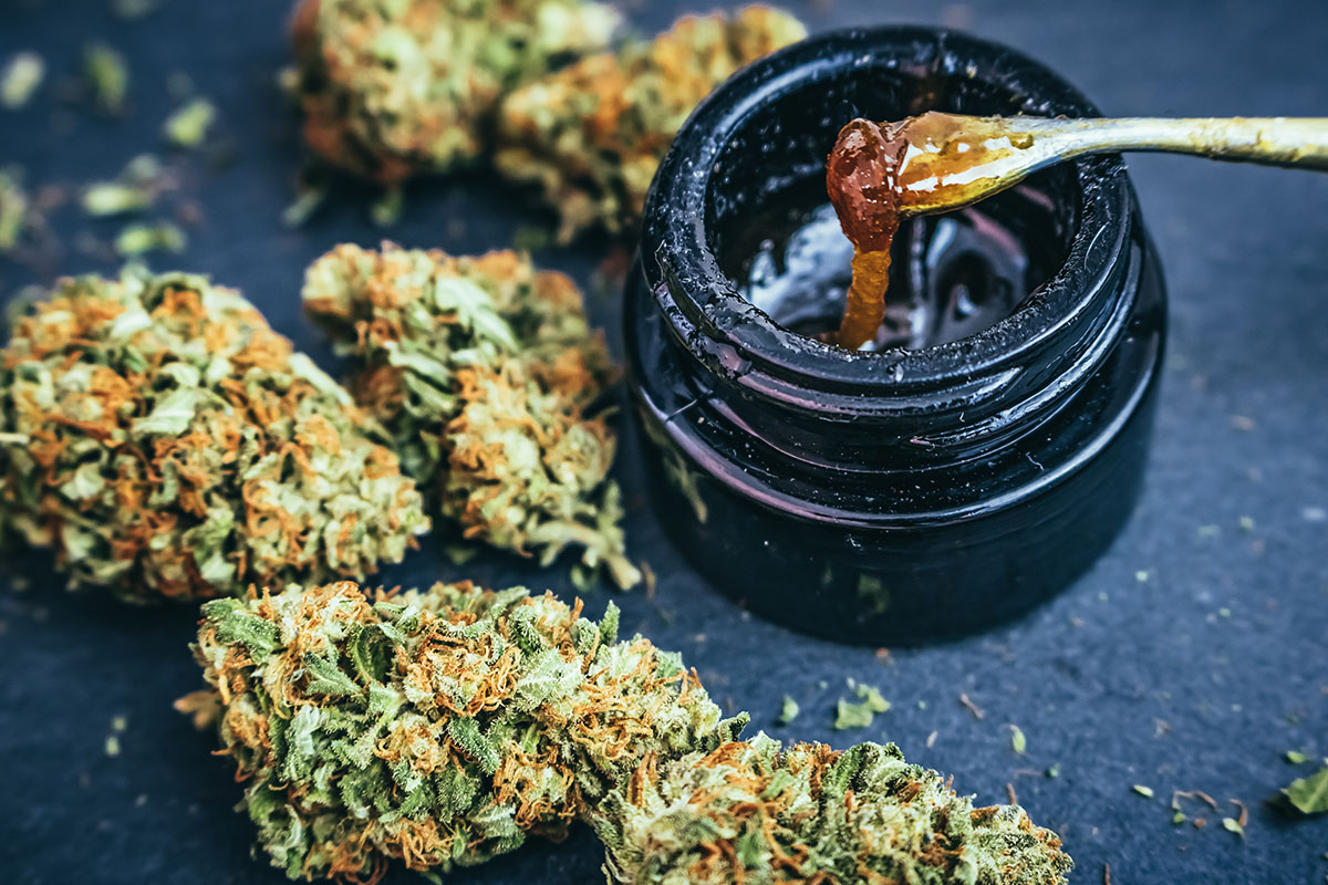 Live resin being scooped out of an opaque jar with a dab tool