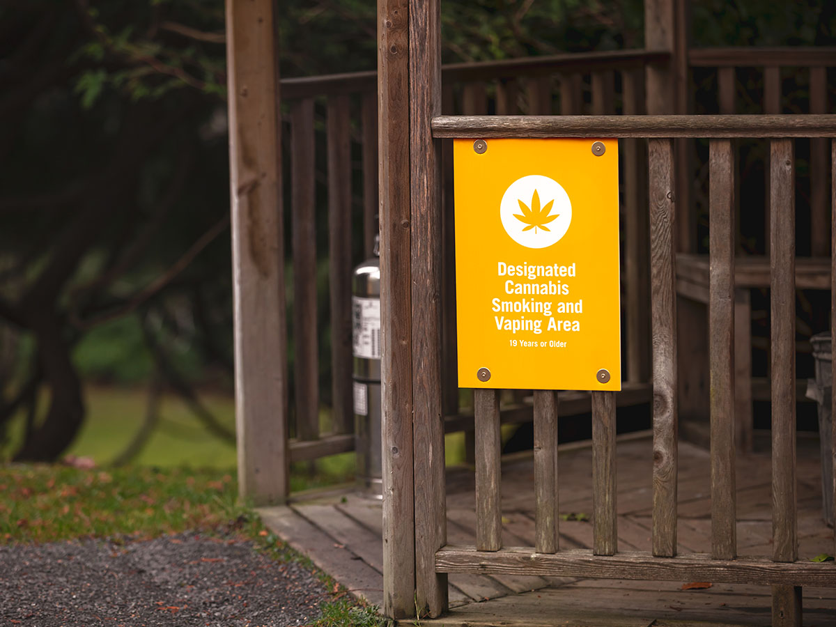 Yellow sign that reads 'designated cannabis smoking and vaping area' on the side of an outdoor gazebo