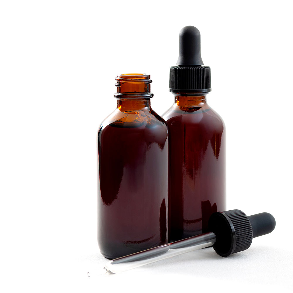 Two opaque tincture bottles, one with the dropper sitting next to it