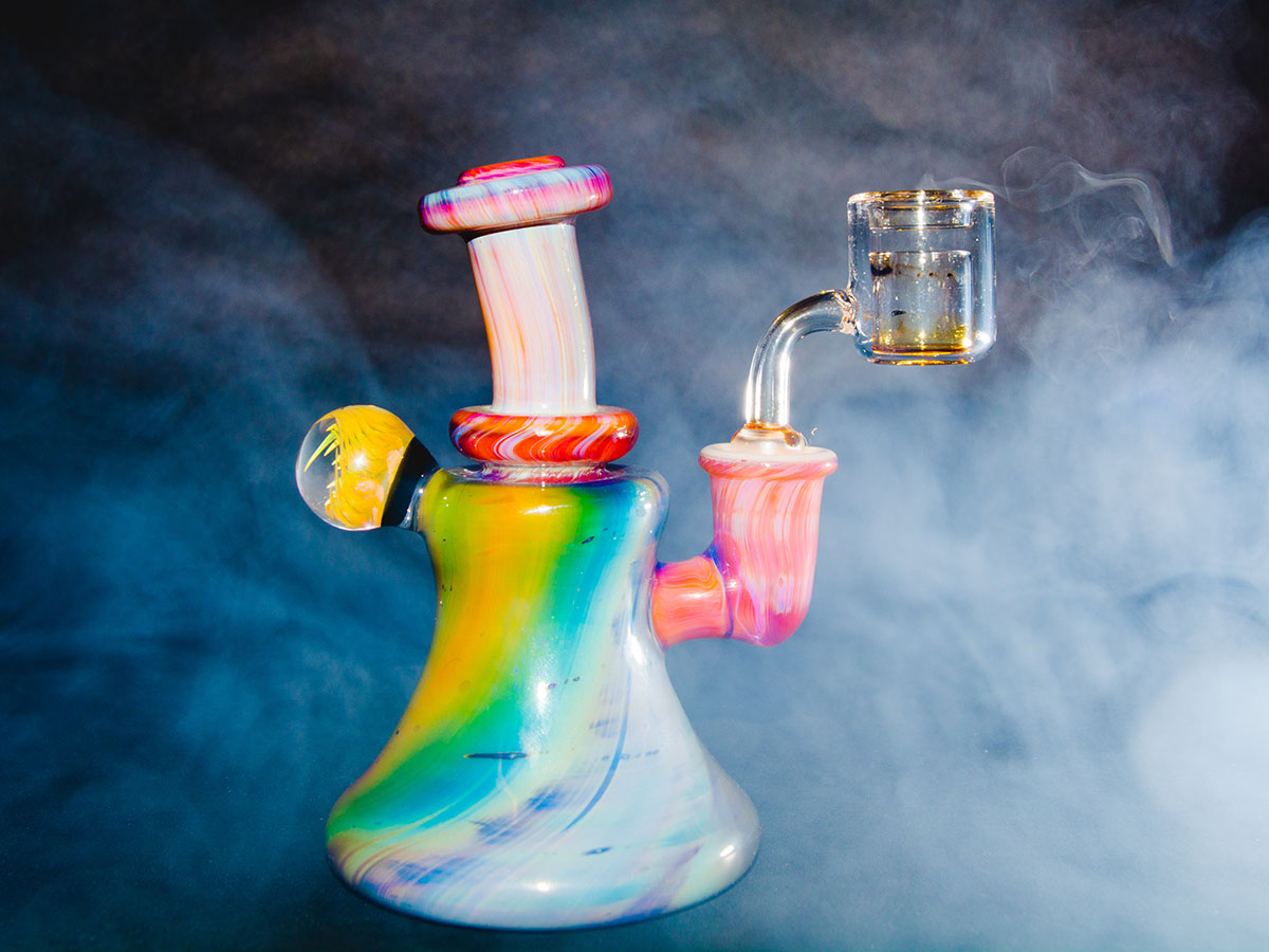 Colorful dab rig on a table in front of a smokey background