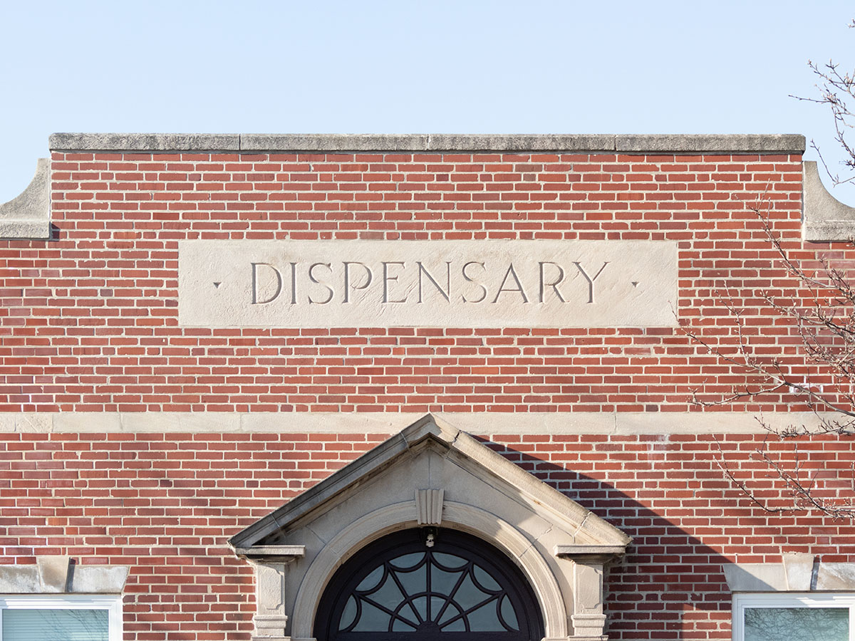 Top half exterior of a brick building that says 'dispensary'